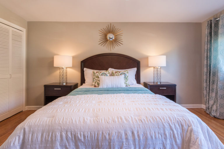 staged bedroom with bedside lamos, mix nightstands and lamps