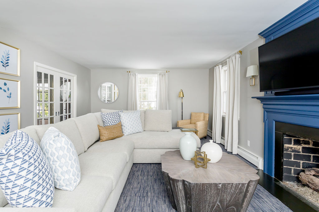cream colored couch with blue and white pillows and blue painted fireplace, home staging tips