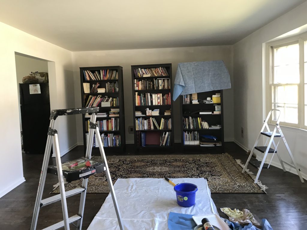 room with book shelves, paint ladder and paint can before transformation of listing