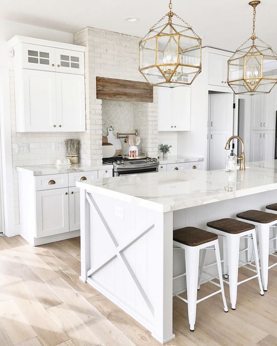 white kitchen design with natural wood floors and gold pendant lights