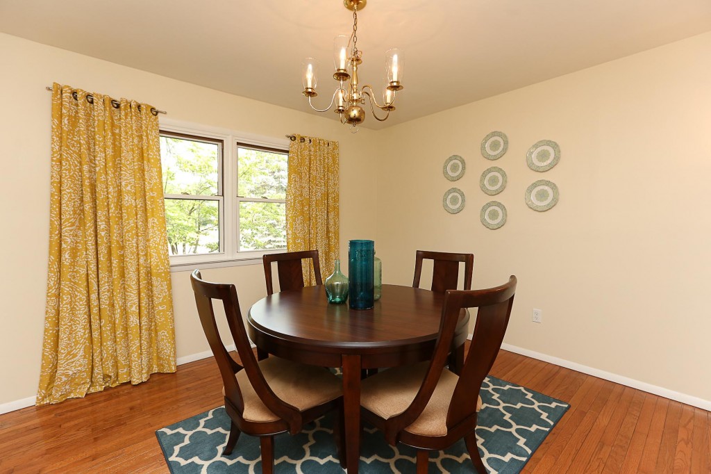 dark wood dining table and chairs with yellow drapes