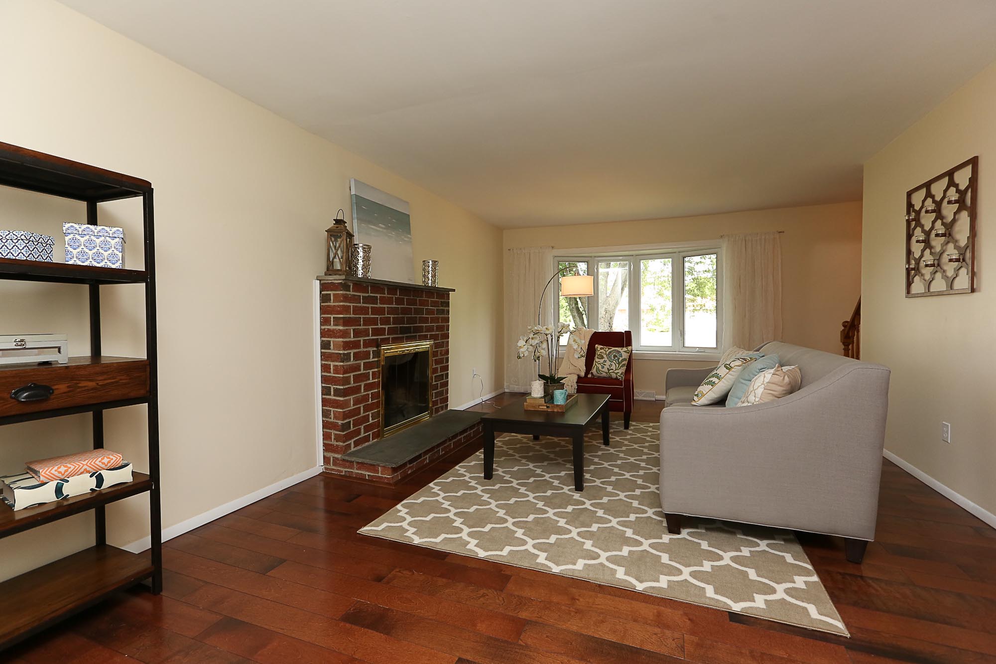 living room that has been staged with brick fireplace coffee table and gray couch