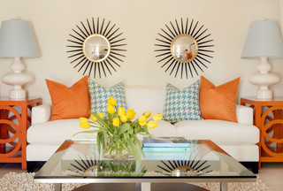 gallery walls, mirrors above white couch with orange pillows