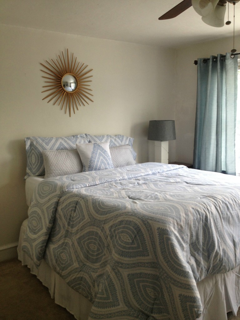 Bedroom that was home staged, blue and white bedspread, sin mirror, the cost of not staging